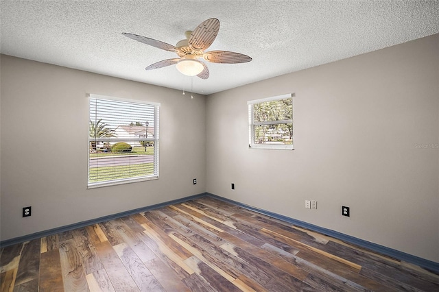 spare room featuring ceiling fan, a textured ceiling, baseboards, and dark wood-type flooring