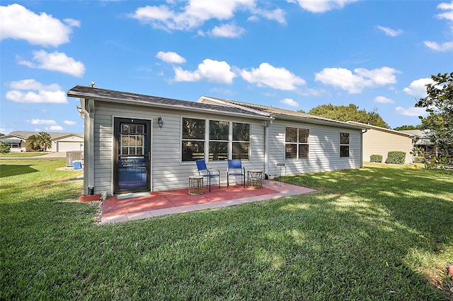 rear view of property featuring a lawn and a patio