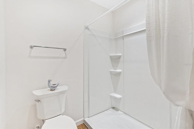 full bathroom with a stall shower and toilet