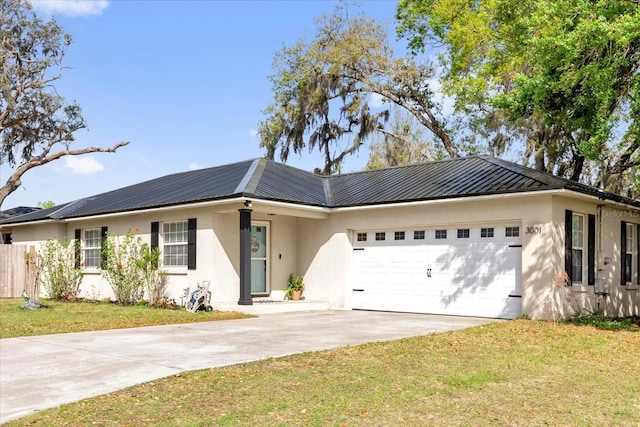 ranch-style home with a garage, concrete driveway, metal roof, and stucco siding