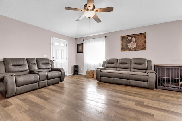 living room featuring wood finished floors, a ceiling fan, and baseboards