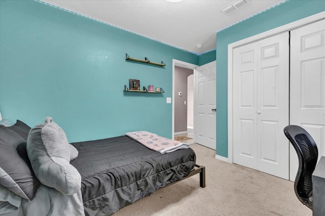 bedroom with light colored carpet, a closet, visible vents, and baseboards