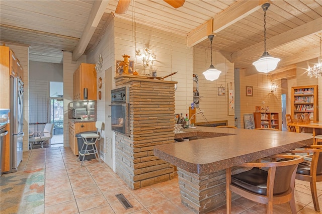 kitchen featuring light tile patterned floors, oven, wood ceiling, visible vents, and beam ceiling