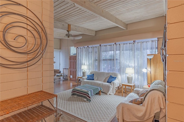 living room featuring wood ceiling, wood finished floors, beam ceiling, and concrete block wall