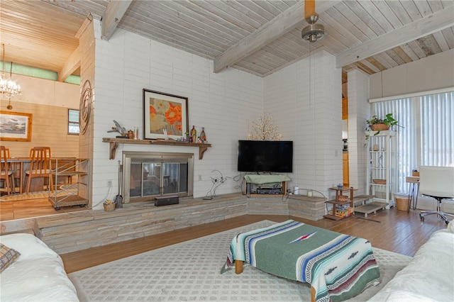 living room featuring a chandelier, a glass covered fireplace, wood finished floors, and wood ceiling