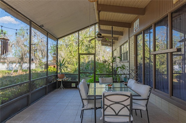 sunroom with a wealth of natural light, beam ceiling, and a ceiling fan