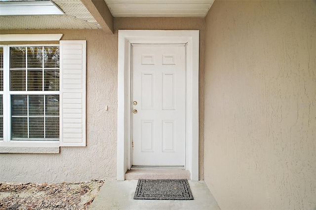 view of exterior entry with stucco siding