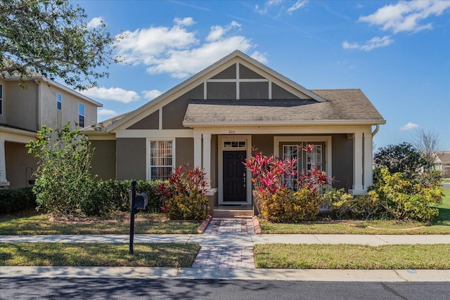 view of front of property featuring roof with shingles and stucco siding