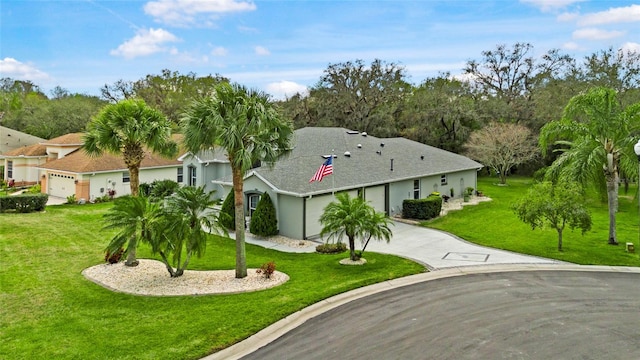 view of front of home featuring driveway, a front lawn, and an attached garage