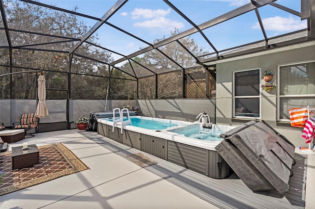 view of pool featuring glass enclosure, a patio area, and hot tub deck surround