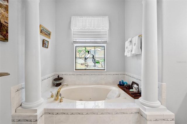 full bath featuring a whirlpool tub and decorative columns