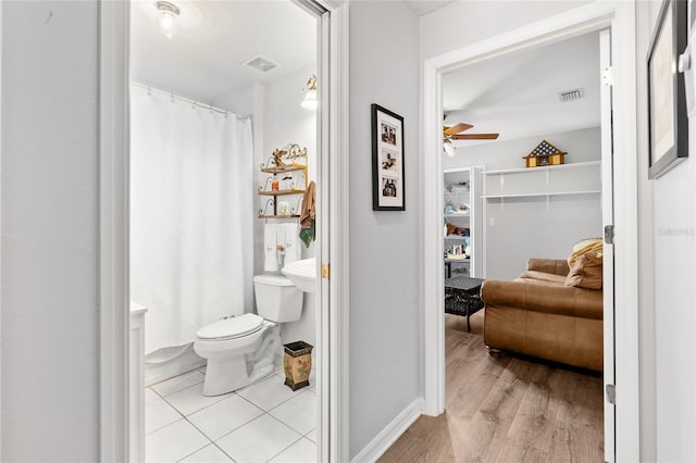 bathroom featuring a ceiling fan, visible vents, toilet, and wood finished floors