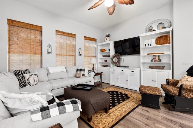 living room with a ceiling fan and light wood finished floors