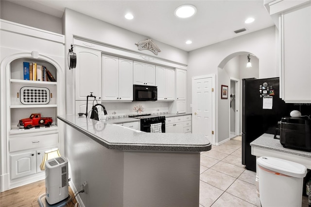 kitchen with arched walkways, a peninsula, visible vents, white cabinetry, and black appliances