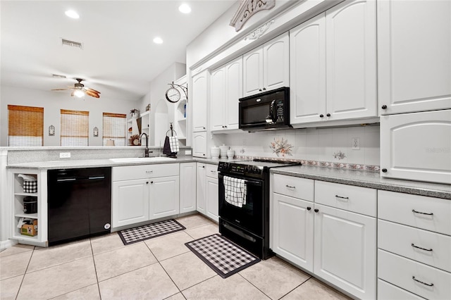 kitchen featuring light tile patterned flooring, a peninsula, a sink, white cabinetry, and black appliances