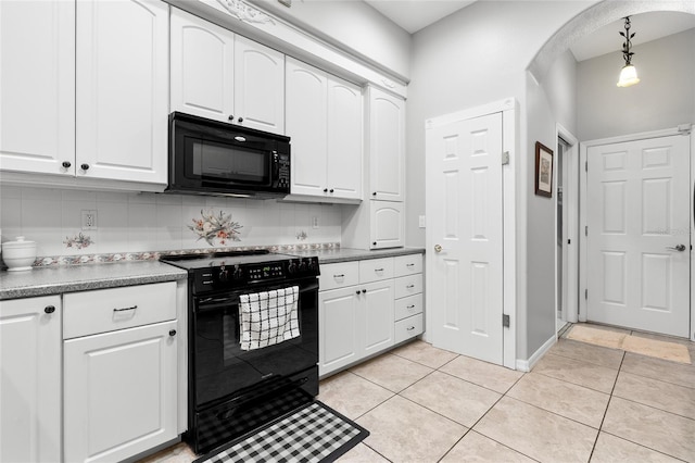 kitchen with arched walkways, light tile patterned floors, white cabinetry, decorative backsplash, and black appliances