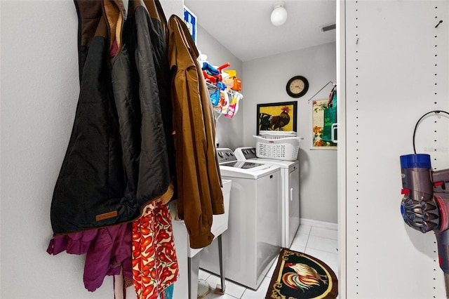 washroom with laundry area, light tile patterned floors, baseboards, visible vents, and washing machine and clothes dryer