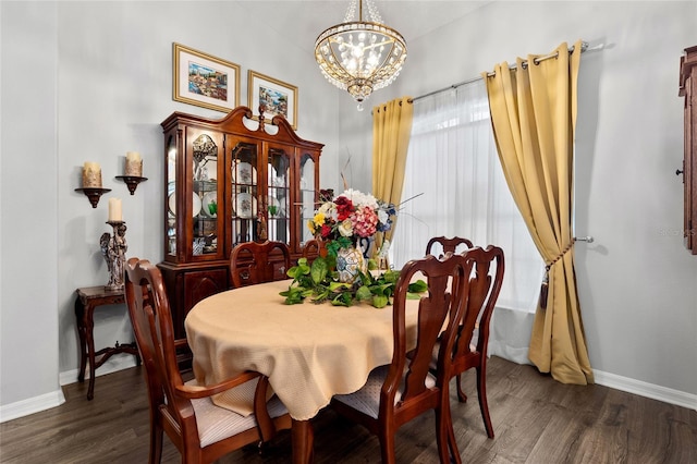 dining area featuring baseboards, a chandelier, and wood finished floors