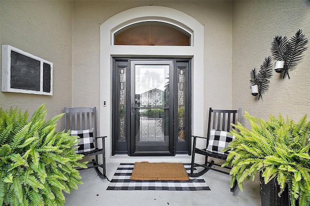 view of exterior entry featuring stucco siding