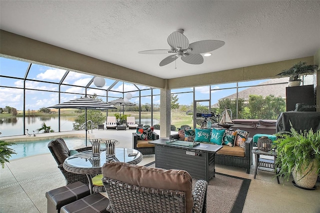 sunroom featuring a water view and ceiling fan