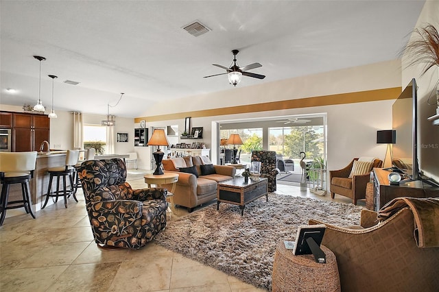 living room with lofted ceiling, visible vents, and a ceiling fan