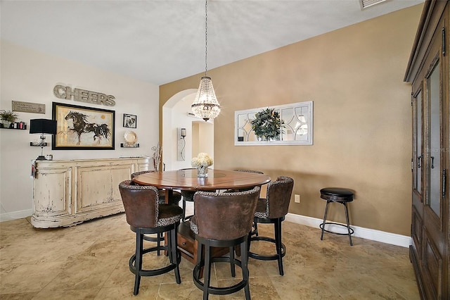 dining space featuring arched walkways and baseboards