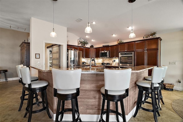 kitchen with vaulted ceiling, visible vents, stainless steel appliances, and decorative backsplash