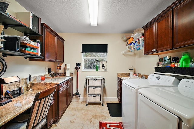 laundry room with cabinet space, a textured ceiling, and washing machine and clothes dryer