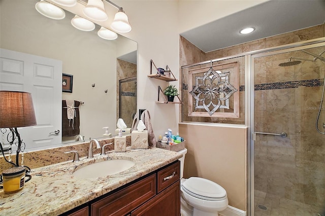 bathroom featuring a stall shower, vanity, and toilet