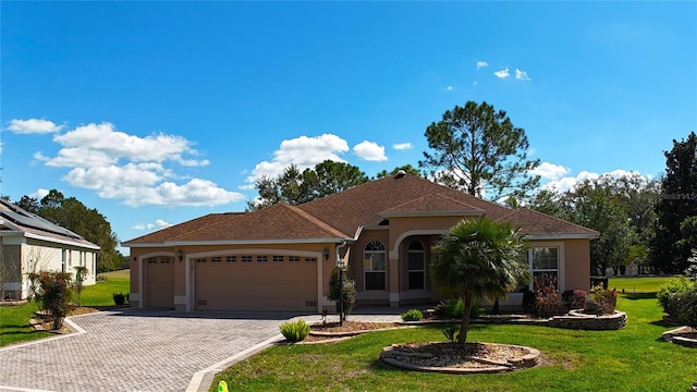 view of front of property with a garage, a front lawn, decorative driveway, and stucco siding