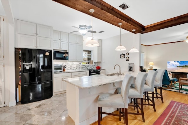 kitchen with tasteful backsplash, black fridge with ice dispenser, a ceiling fan, a sink, and a peninsula