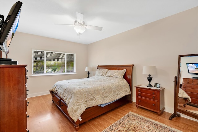 bedroom featuring a ceiling fan, baseboards, and light wood finished floors