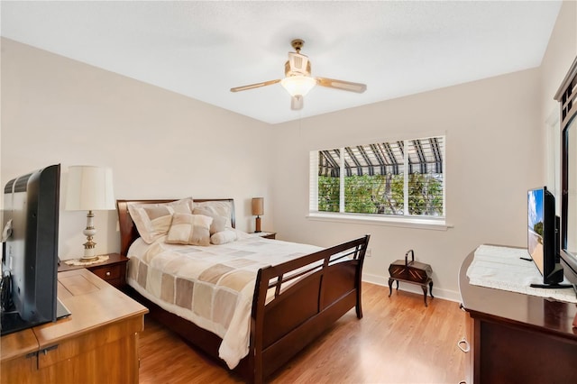 bedroom featuring baseboards, a ceiling fan, and light wood-style floors