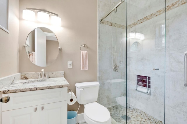 full bath with tiled shower, vanity, and toilet