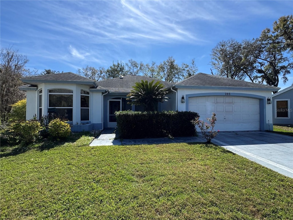 ranch-style house featuring a front lawn, driveway, an attached garage, and stucco siding