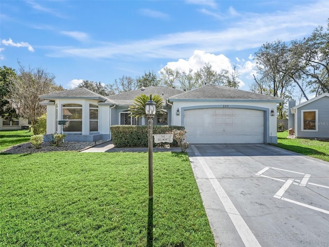 ranch-style house with driveway, a garage, a shingled roof, stucco siding, and a front yard