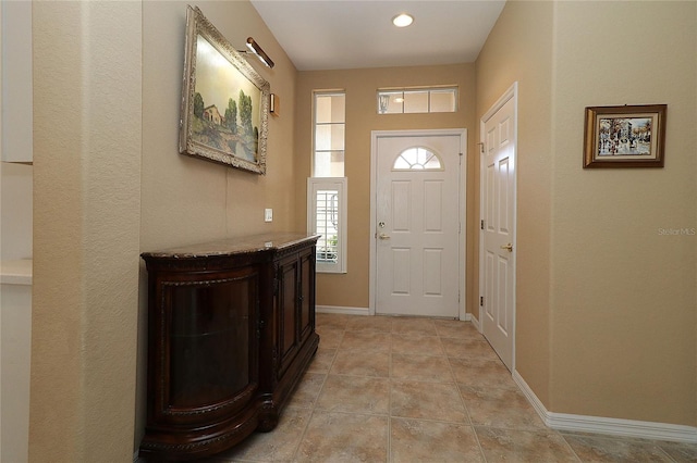 entryway with light tile patterned floors and baseboards