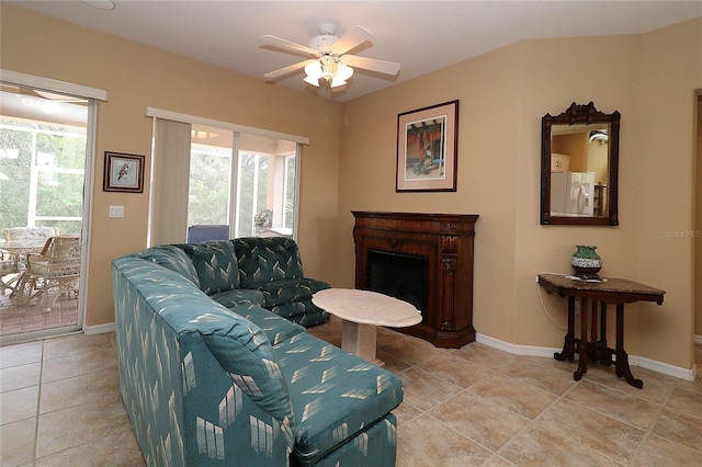 living room with a ceiling fan, a wealth of natural light, a fireplace, and baseboards