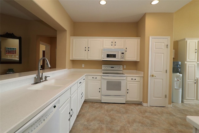 kitchen with light countertops, white appliances, a sink, and white cabinetry