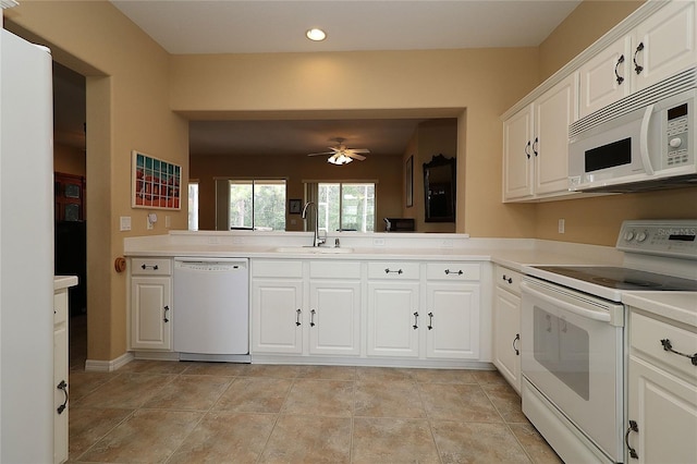 kitchen with white appliances, a sink, a ceiling fan, white cabinets, and light countertops