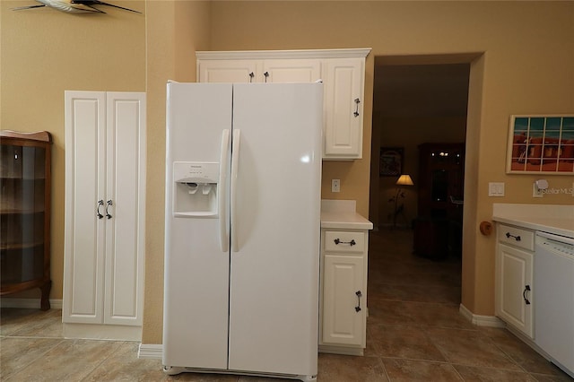 kitchen featuring light countertops, white appliances, white cabinetry, and baseboards