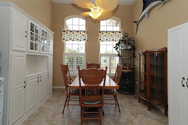 dining room featuring a towering ceiling and baseboards