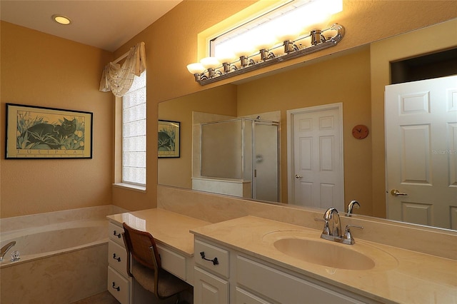 bathroom with a stall shower, a garden tub, and vanity