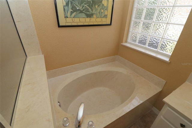 bathroom featuring a garden tub and vanity