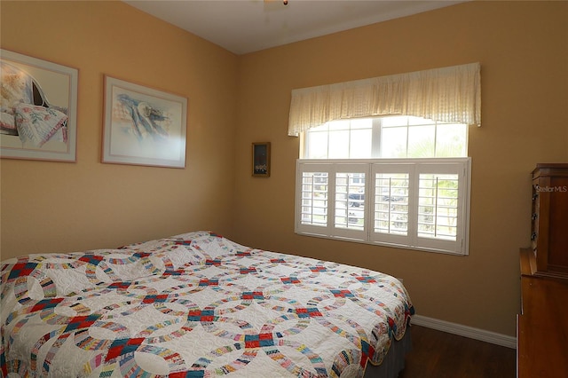 bedroom with baseboards and wood finished floors