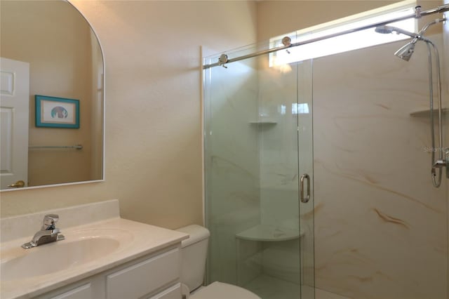 bathroom featuring vanity, a marble finish shower, and toilet