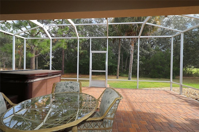 view of patio / terrace featuring a lanai, a hot tub, and outdoor dining area