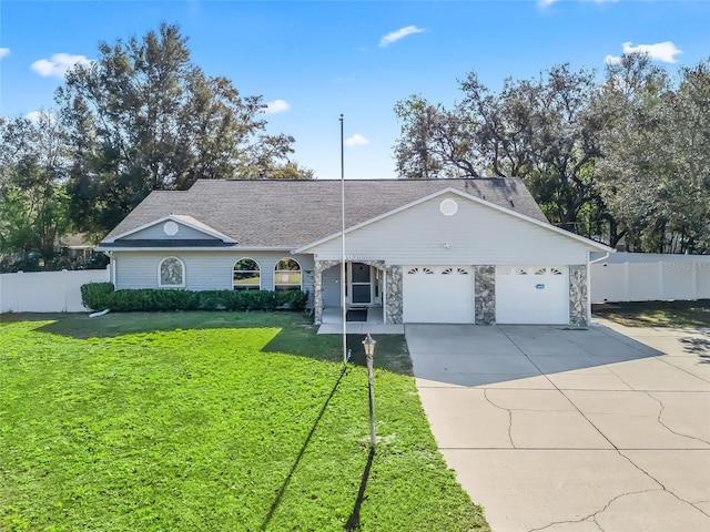 single story home featuring a garage, fence, driveway, stone siding, and a front yard