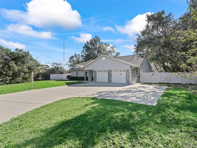 view of front of house with a garage, fence, concrete driveway, stone siding, and a front lawn