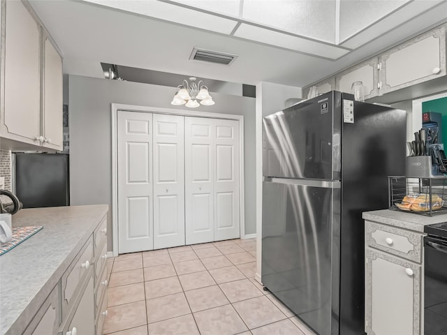 kitchen with white cabinets, visible vents, light countertops, and freestanding refrigerator